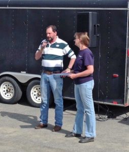 Town manager speaking in microphone with credit union CEO watching