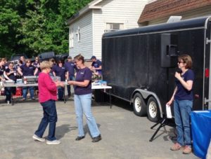 employees presenting checks to food cuboard representatives