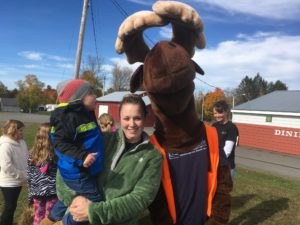 Maine Highlands employee with child posing with Monty Moose