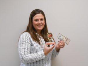 girl holding cash prize and trophy