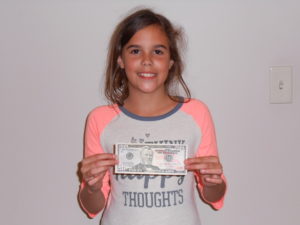 young girl holding cash prize