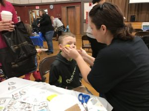 boy getting his face painted at event