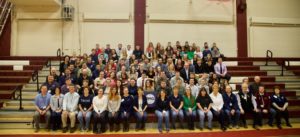 students, teachers, and volunteers posing on bleachers at financial fitness fair