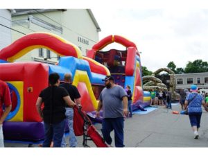 people enjoying giant inflatable obstacle course at festival