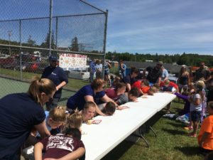 about 12 children enjoying pie eating contest