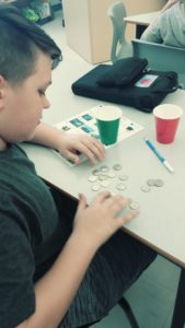 boy in classroom counting coins