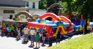 inflatable obstacle courses and several people waiting their turn to use them