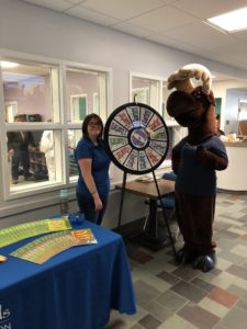 employee posing with Monty Moose at prize wheel