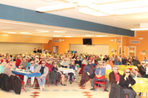 crowd of people sitting at tables wearing sunglasses