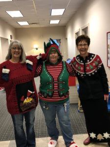 employees in ugly Christmas sweaters