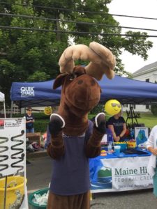 Monty Moose at festival holding two whoopie pies