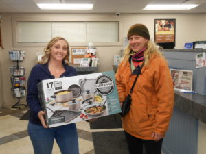 Third place winner holding set of cookware with Greenville employee