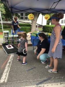 child playing bean bag toss game at festival