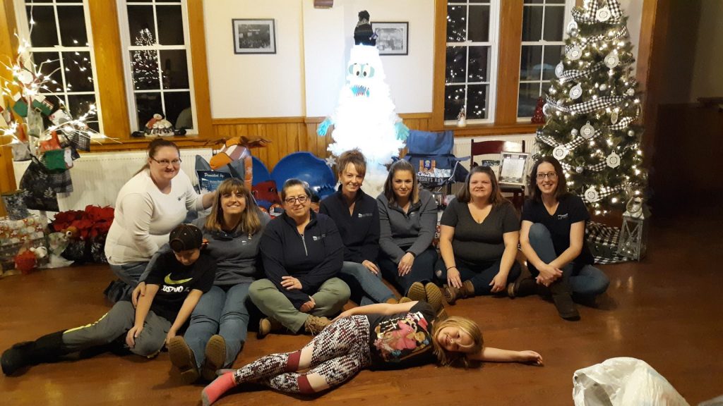 group of employees in front of Christmas tree